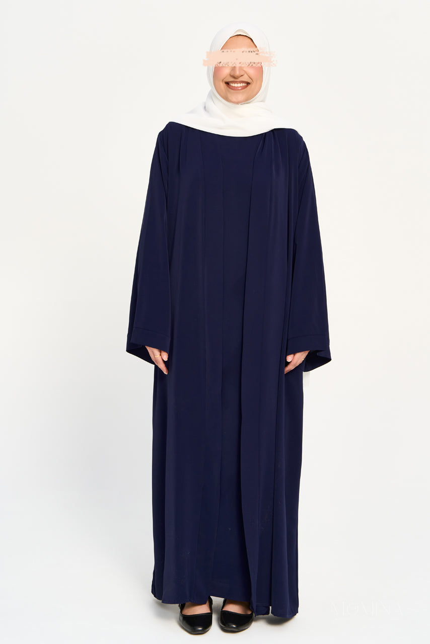 Woman wearing a navy blue abaya set with a white hijab on a white background by Momina Hijabs
