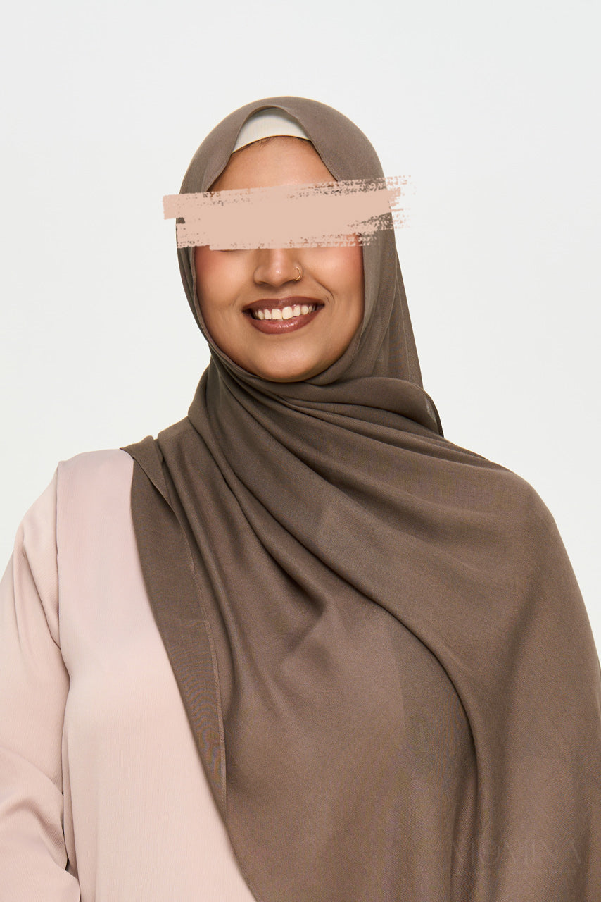 Muslim woman wearing a brown modal hijab on a white background by Momina Hijabs
