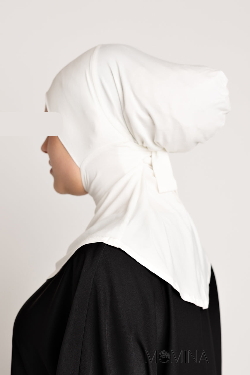 A hijabi model wearing a white full coverage ninja undercap from momina hijabs - Side profile