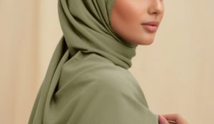 Close up short of a model wearing a muted green premium rayon hijab