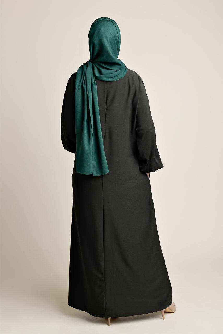 Model wearing a classic Abaya with side pockets in a dark olive green - Rear pose - Momina Hijabs