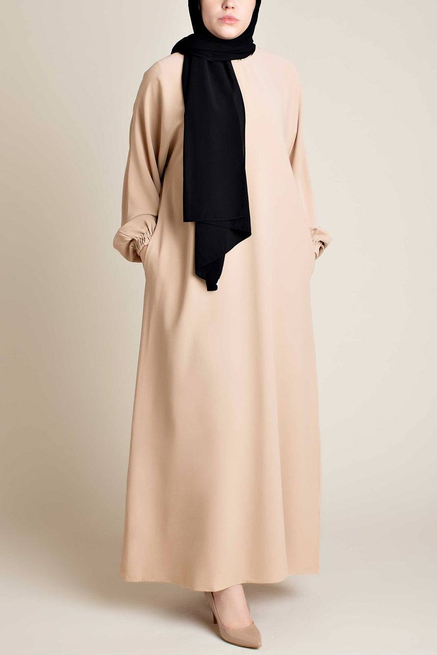 Model wearing a classic Abaya with side pockets in a cream color - Front pose - Momina HIjabs