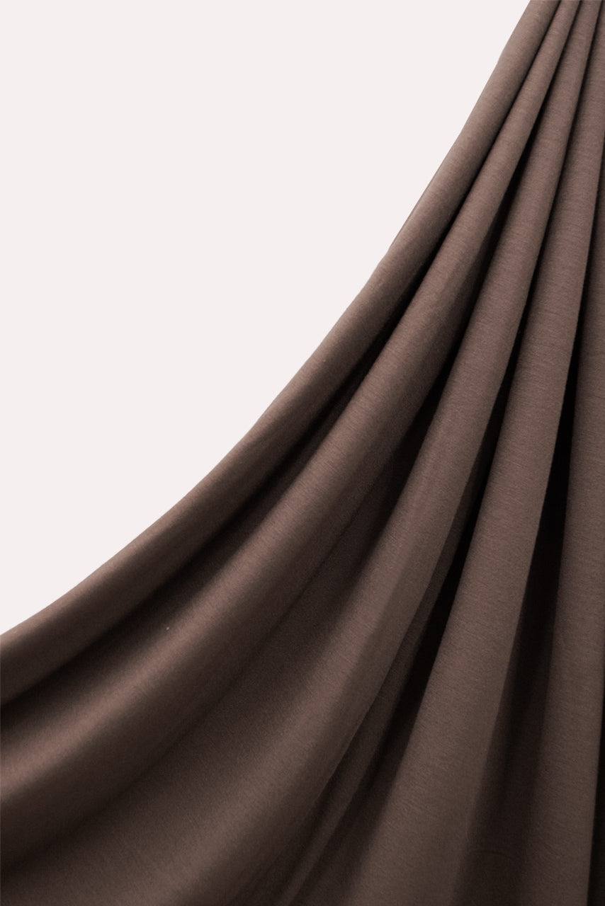 Hanging image of a muted dark brown jersey hijab by Momina Hijabs